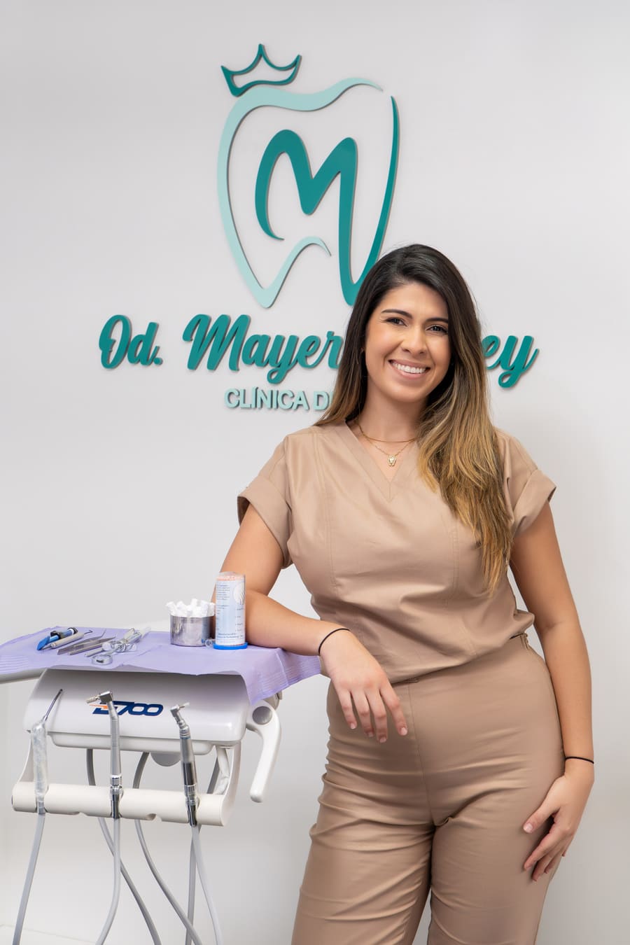 Mayerlin Rey en su consulta, junto al logo de la clínica en la pared.